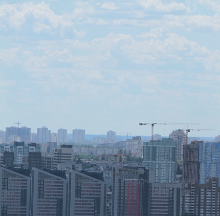 Building crane and building under construction against blue sky.の写真素材