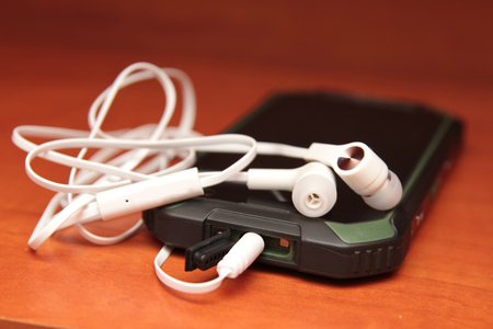 smartphone and headphones, side view, closeup special photo effect - soft focus, vignette.の写真素材