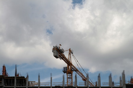 Building crane and building under construction against blue skyの写真素材