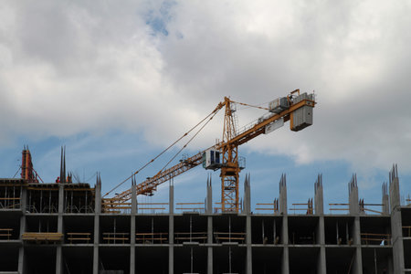 Building crane and building under construction against blue sky
