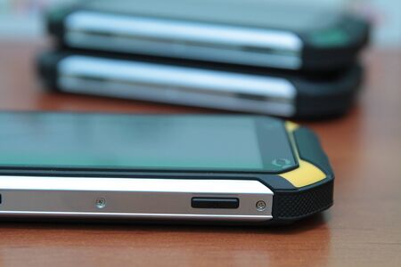 Protected mobile phone on a wooden table.の写真素材