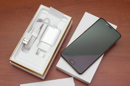 Black smartphone lying on a wooden table