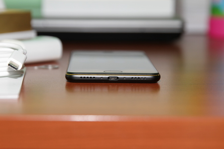 Black smartphone lying on a wooden tableの写真素材