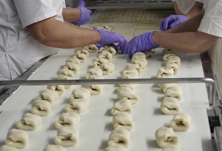 Production of bakery products in a bakery. The baker kneads the dough for baking buns.の写真素材