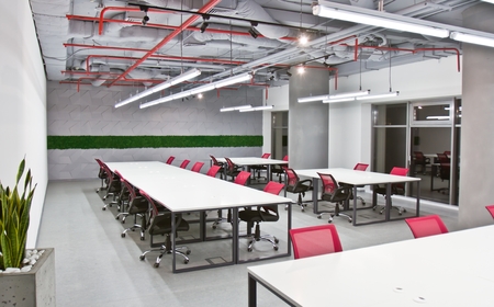 Luxurious office space with large white tables and chairs and modern design. Conference room interior with empty chairs and a projector screen.の写真素材
