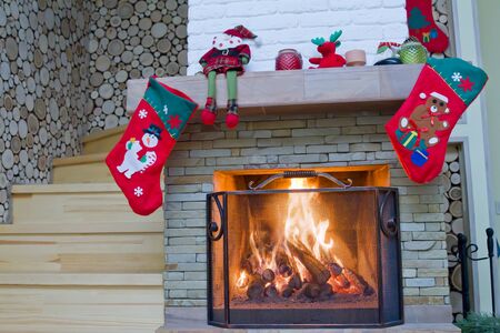 Fireplace with Christmas decorations. The firewood is burning in the fireplaceの写真素材
