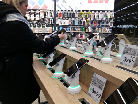 Kiev, March 6, 2018, Ukraine. The buyer chooses a smartphone on the counter in one of the...