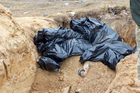 Bucha, Kyiv region, Ukraine - April 2022: War between Russia and Ukraine. Mass grave of civilians shot by the troops of the Russian army, buried on the territory of the church.のeditorial素材