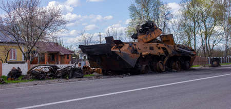 Kolychevka, Ivanovka, Chernihiv region - Apr 2022: War Ukraine Russia. The ruins of the house after the bombing by the Russian army. Destroyed tank and house after a missile attack.のeditorial素材