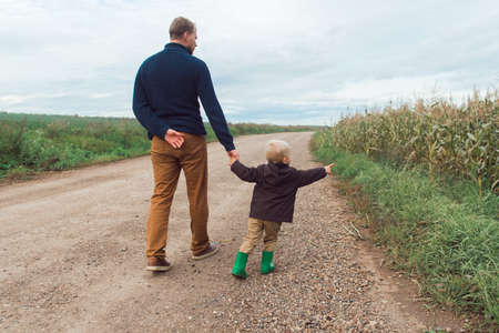 family walking in corn field at autumn, kid hug parentの写真素材