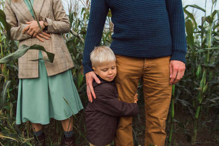 family walking in corn field at autumn, kid hug parentの写真素材