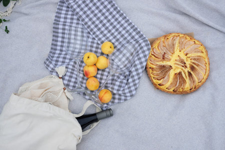 picnic in nature - pear pie, fruit and a bottle of wine on a blanketの写真素材