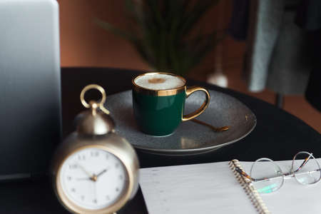 cup of coffee and businesses details on table, work place of designerの写真素材