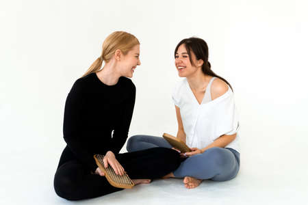 Two girls wearing sport uniform holding sadhu board after workoutの写真素材