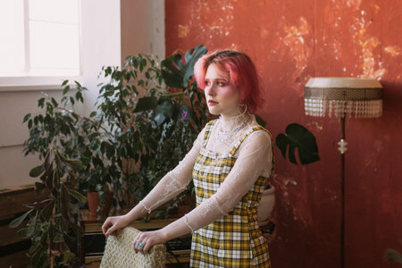Young fashion stylish woman standing vintage studio, bright make up and colored hair