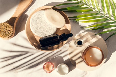 set of skin care and wellness products - serum bottle, exfoliation brush and soap, cream and sponge