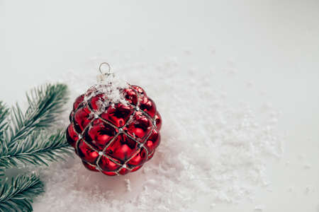 festive christmas ball on white background with snow and fir branchesの写真素材
