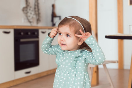 Cute little girl wearing polka dot dress portraitat homeの写真素材