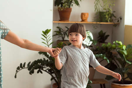 Loving mother holding hand boy with Down syndromeの写真素材