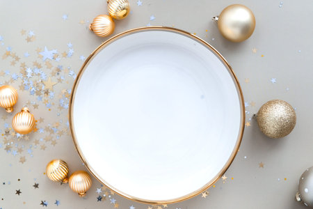 empty festive holiday dish on beige background with chrostmas balls and confetti, top view