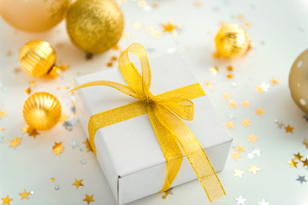 new year decorations golden color with confetti and gift box on beige color background