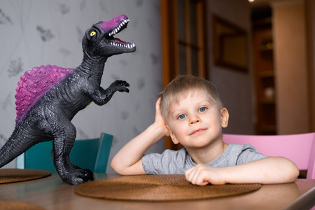 portrait of boy playing big dinosaur toyの写真素材