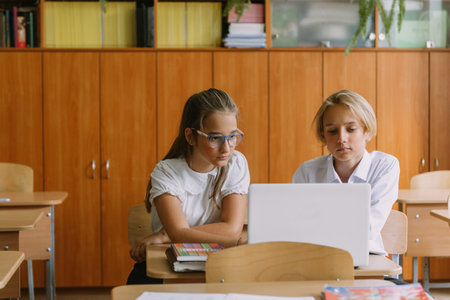 teen students working together using laptop in classroomの写真素材