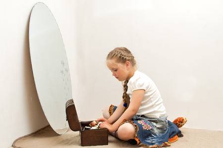 The photo shows a little girl, she tries to imitate adults and look fashionable and stylish.の写真素材