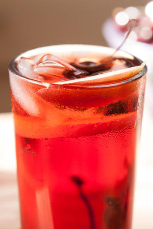 sweet cherry lemonade with ice in a transparent glassの写真素材