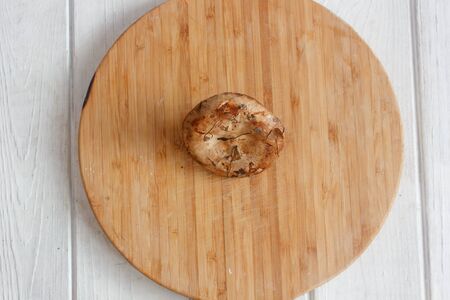 forest mushrooms on brown wooden board and white tableの写真素材