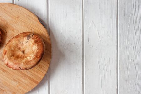 forest mushrooms on brown wooden board and white tableの写真素材