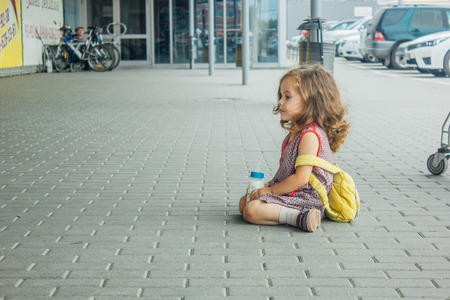 little girl with backpack and baby bottle travel in the airport or railway station, kids travelの写真素材