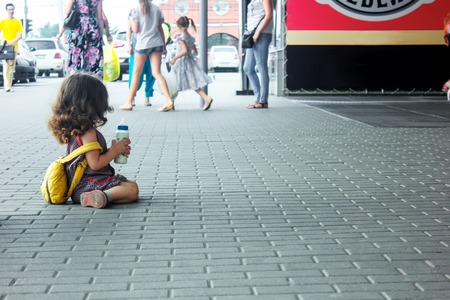 little girl with backpack and baby bottle travel in the airport or railway station, kids travelの写真素材