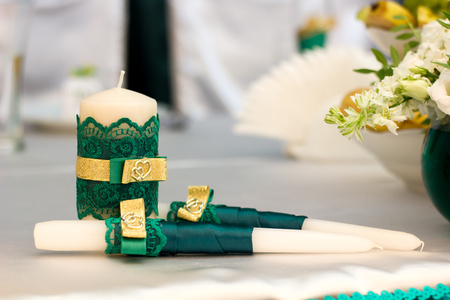 White wedding candles with green decorationの写真素材