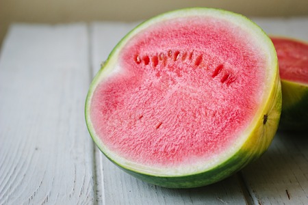 Halfs of delicious red watermelon on wooden background.の写真素材