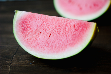 Small watermelon, piecies of delicious ripe watermelon on wooden board.の写真素材