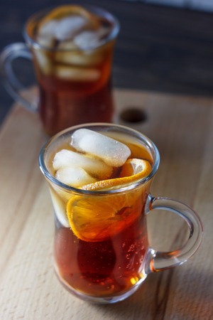 Glass of rum and cola with the ice cubes and slice of orangeの写真素材