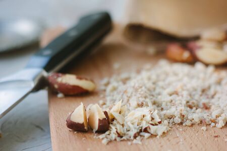 Brazil nuts on wooden board chopped by chief knife.の写真素材