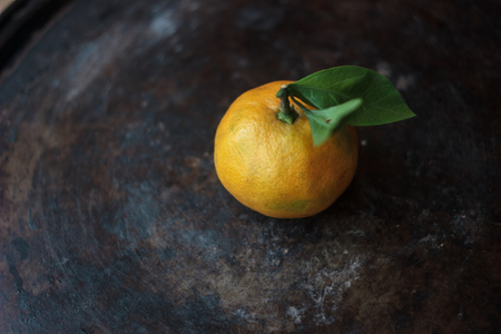 Mandarine orange on a black metal backgroundの写真素材
