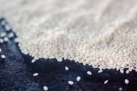 White sesame seeds over the black metal trayの写真素材