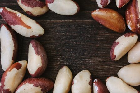 Brazil nuts over the brown table, top view, empty space.の写真素材
