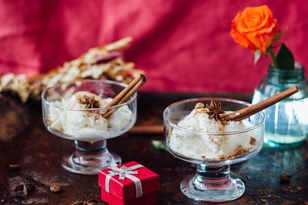 White ice cream with cinnamon and star anise on black rustic boardの写真素材