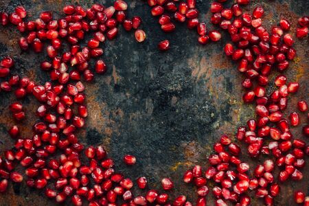 Pomegranate seeds frame over black rustic surfaceの写真素材