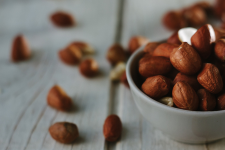 Dry peanuts in white bowl over the white table.の写真素材