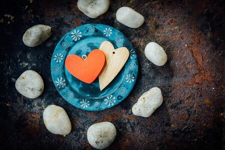 Two hearts on blue plate over rustic background.の写真素材