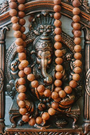 Hindu God - Ganesha with rudraksha rosary on white wooden background.の写真素材