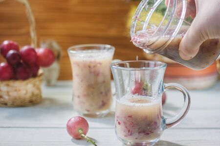 Grape smoothie over the white table whith grapesの写真素材