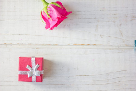 Red box with gift on white wooden surface.の写真素材
