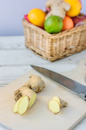 Ginger slices over wooden table with fresh fruitsの写真素材
