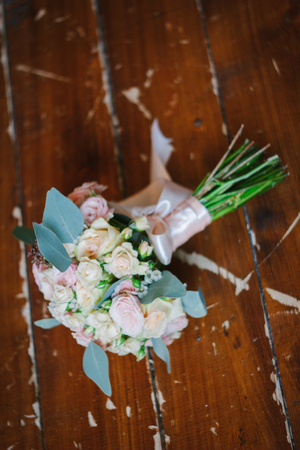 Beutiful wedding bouquet over brown wooden floorの写真素材
